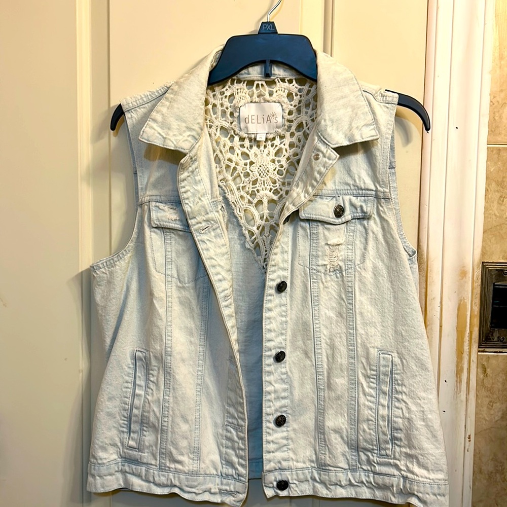 Size XL Delia’s sleeveless distressed light wash denim jacket.